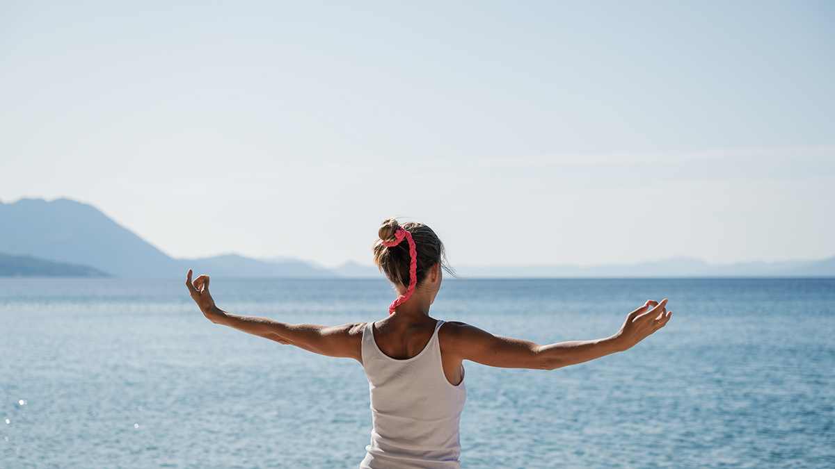 woman practicing mindfulness near ocean